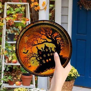 Detail of round Halloween pumpkin hanging ornament with chain for festive porch decor