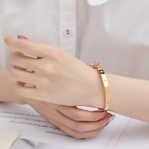Elegant gold-plated stainless steel four-leaf clover bangle with inlaid diamonds on model
