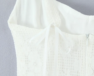 Détail d'une robe en dentelle blanche avec nœud papillon et fermeture éclair invisible