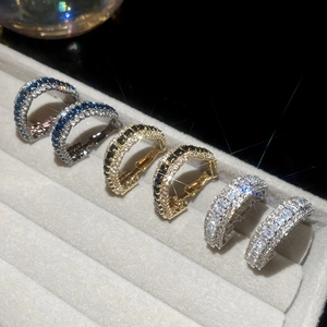 Close-up of geometric triangle C-shape hoop earrings with colorful pavé cubic zirconia
