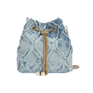 Detail of light blue denim bucket bag featuring quilted diamond pattern and pearl drawstring