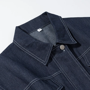 Detailed close-up of dark blue denim dress collar with metal button and white stitching