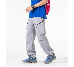 Detail of gray cargo pants showing large utility side pockets with secure zippers
