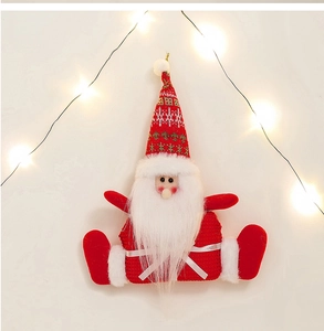Close-up of a plush Santa Claus ornament with a red knit hat and fluffy white beard