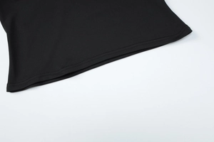 Detail view of the black knit fabric with professional double-needle stitching on hemline