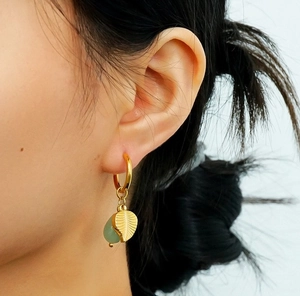 Détail de la feuille dorée et pierre goutte verte sur boucle d'oreille en or 18k