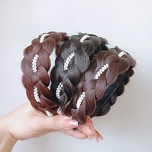Detail of braided fishtail headband with white pearl accents in black and brown shades