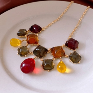 Detail of vintage square resin pendant necklace with colorful stones in a gold frame