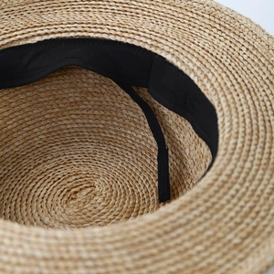 Vista interna di un cappello di paglia con fascia nera e cordoncino di regolazione