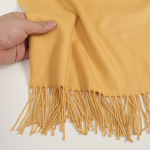 Thick ginger cashmere-feel scarf with long tassels showing soft texture and hand touch