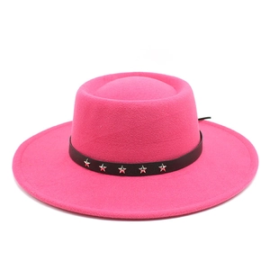 Detail of rose red wool fedora featuring a black leather band with silver star studs