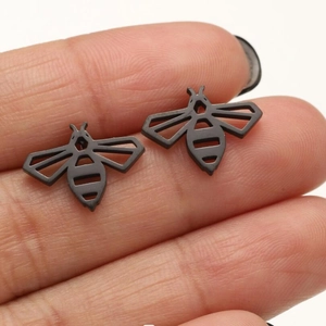 Macro detail of black bee stud earrings with intricate cutout wings and matte finish