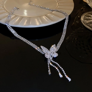 Détail du collier papillon argenté avec pompons en zircon et chaînes multicouches élégantes