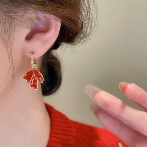 Gros plan détaillé de la boucle d'oreille feuille d'érable rouge sur une oreille