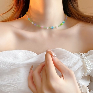 Close-up of a colorful beaded flower choker necklace worn on a model's collarbone