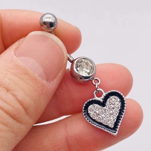 Macro shot of silver belly ring with black enamel heart pendant and pavé rhinestones