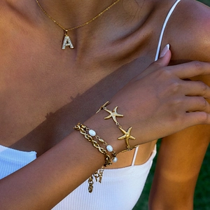 Gold 18K starfish bracelet set with letter A pendant and pearls on a model