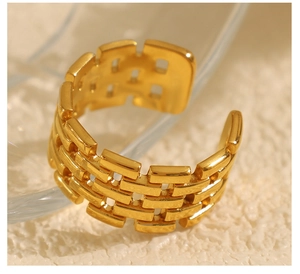 Close-up of a gold-finish titanium open ring with a watchband-inspired irregular design