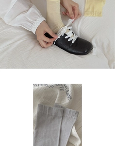 Detail view of yellow and grey ribbed silk socks with elegant ribbon lace-up design