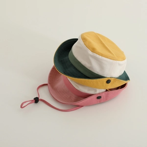 Close-up of kids color-block bucket hat featuring adjustable windproof rope and snap buttons