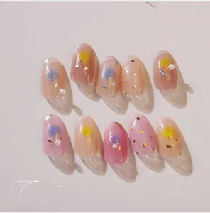 Détail de faux ongles en amande avec motifs de roses en 3D et décorations de perles
