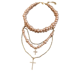 Double-layer necklace with champagne pearls, gold chains and sparkling rhinestone crosses