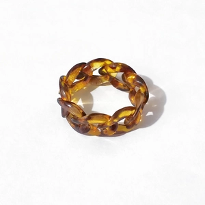 Close-up of amber resin chain link ring with a translucent tortoiseshell texture design