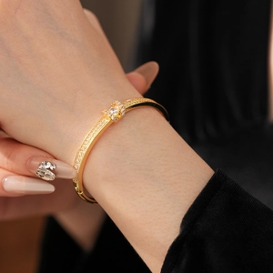 Macro detail of gold-plated oval horseshoe buckle bracelet with paved zircon crystals