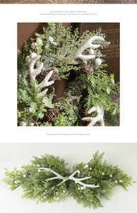Close-up of white resin antlers and frosted pine branches in a Christmas wreath