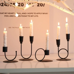Porte-bougie minimaliste en métal noir en forme de U sur un décor intérieur chaleureux