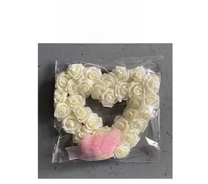 Détail de l'emballage d'une couronne de roses blanches en cœur avec nœud en organza