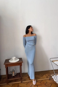 Detail of light blue off-shoulder knitted top and slim skirt set with soft lighting