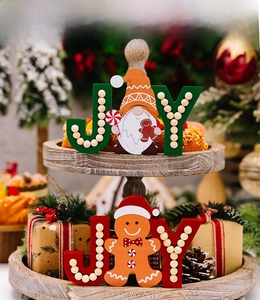Close-up of wooden JOY Christmas ornaments with gnome and gingerbread man figures