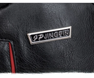 Close-up of black litchi pattern PU leather texture and metal logo plaque on chest bag