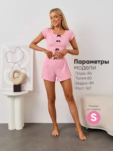 Detail of pink knit two-piece set featuring delicate black bows and ribbed texture