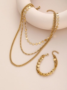 Macro shot of gold-plated multi-layer necklace and bracelet with geometric diamond charms