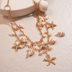 Close-up of golden layered necklace with starfish, shell pendants and imitation pearls