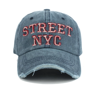 Detail of red STREET NYC embroidery and distressed brim on washed blue cotton baseball cap