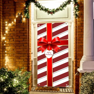 Outdoor Christmas door banner with red stripes and large festive bow on brick wall