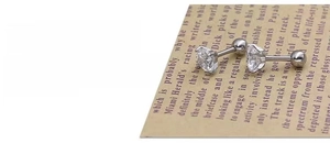 Detailed macro view of four-claw zircon stud earrings with polished mirror finish surface