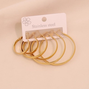 Three pairs of golden stainless steel hoop earrings in varying sizes on display card