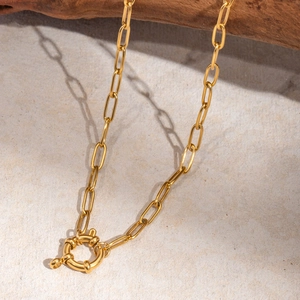 Collana a catena a graffetta in oro 18k retrò con chiusura tonda su un ramo di legno