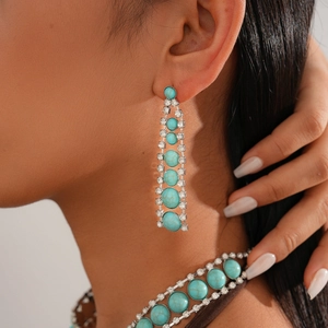 Detail of bohemian necklace and earrings set with turquoise stones and white rhinestones