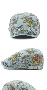 Detail view of denim flat cap with colorful floral patterns and metal side buckle