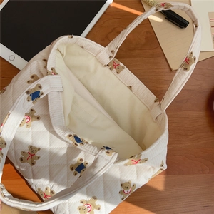 Detail of quilted bear print tote bag showing soft rhombic stitching and inner lining