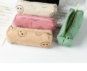 Corduroy pencil case detail showing various colors with cute smiley face patterns