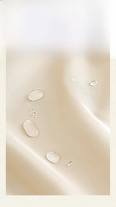 Detail of waterproof beige fabric showing water repellent coating and droplet texture