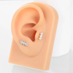Detail showing G23 titanium ear stud with three rectangle zircons on a silicone ear model