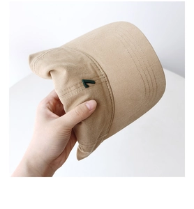 Detail showing flexible cotton fabric and embroidered green number 7 on the khaki cap