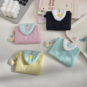 Macro shot of macaron-colored fabric card holders with bear charms and snap buttons
